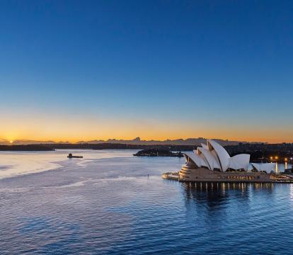 A long shot of the Sydney opera house at sunset.