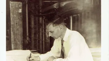 An old polaroid picture of a man sketching.