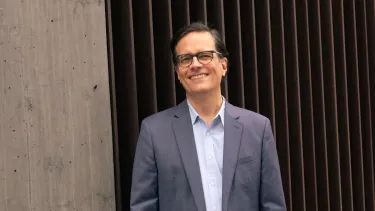 A man with short black hairs wearing a suit.