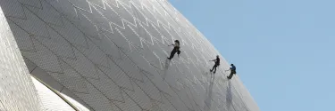 Sydney opera house staff inspecting the tiles on the sails of the building.