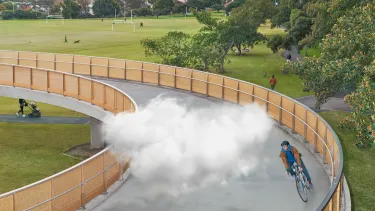 A cloud moving with a man as he cycles on a bridge.