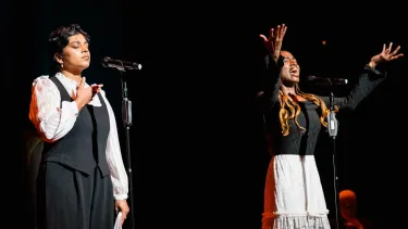 Two women delivering a slam poem.