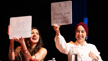 Two judges raising score cards.