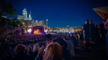 Concertgoers at a show outside in front of the Sydney Opera House.
