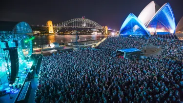 Concertgoers at a show outside in front of the Sydney Opera House.