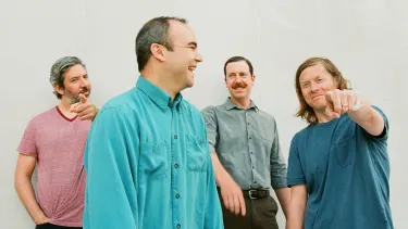 Four men from a pop band Future Islands standing together.