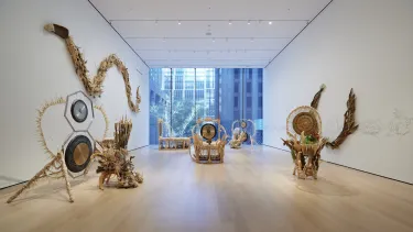 In a long room with white walls and a floor to ceiling window features cream and beige sculptures representing the artists battle with cancer.