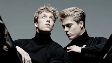 Lucas and Arthur Jussen stand next to each other in black shirts.