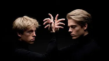 Lucas and Arthur Jussen stand in front of each other with hands raised.