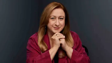 Simone Young wears a red shirt.