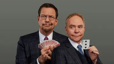 Two men in suit holding play cards, make funny faces.