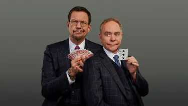 Two men in suit holding play cards, make funny faces.