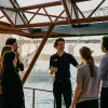 A tour guide with a group of people outside the Sydney opera house.