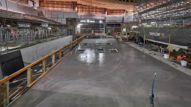 Construction workers pouring concrete into the new steel frame of the stage.