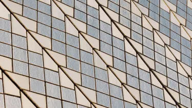 A close up of criss-cross tiles installed in Sydney opera house.