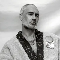 Black and white portrait of a man with short hair and a beard, exuding a confident and introspective mood.